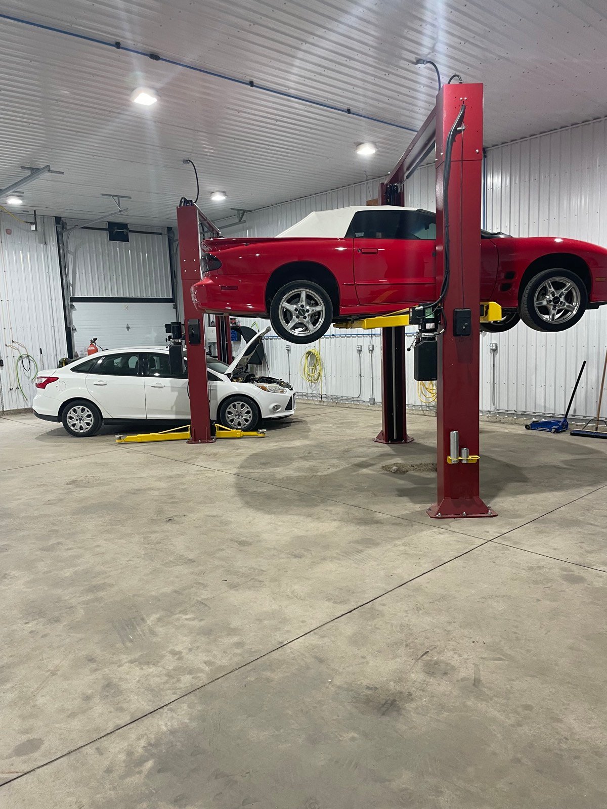 Red car raised on a two-post lift